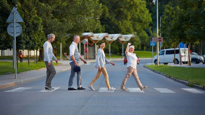 Passanten laufen über einen Zebrastreifen.