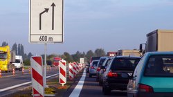 Autos vor einem Schild zum Spur-Wegfall