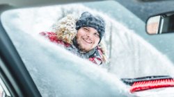 Frau schaut durch halb gekratzte Scheibe ins Auto rein.