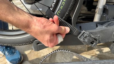 Mann hält Zurrgurt eines Fahrradträgers in der Hand. 