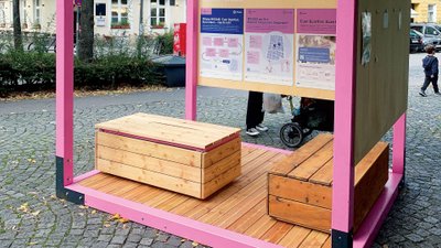 Ein rosafarbener Infostand zum Projekt MOSAIQ 