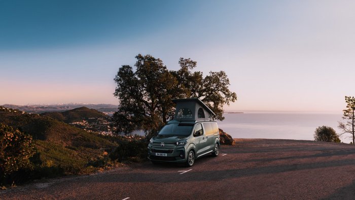 Ein Citroën Holidays Camper steht vor einer Landschaft am Meer.