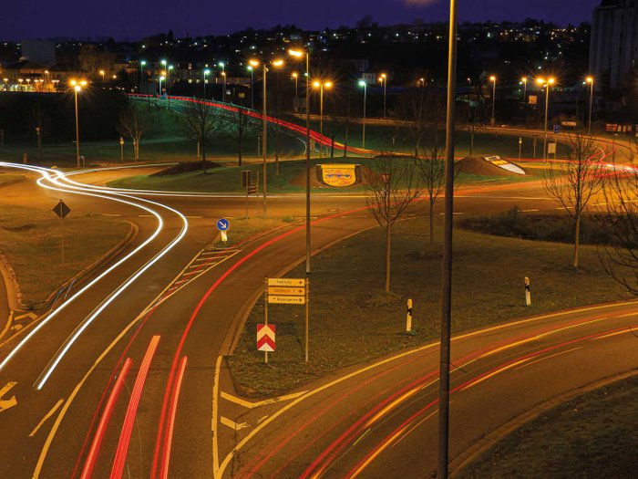 Ein Kreisverkehr bei Nacht mit Lichtspuren.