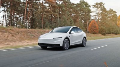 Ein Tesla Model Y fährt auf einer Landstraße.