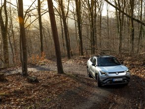 Suzuki eVitara fährt auf einem matschigen Waldweg durch die Kurve.