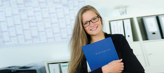 Auszubildende mit blauer Mappe in der Hand.